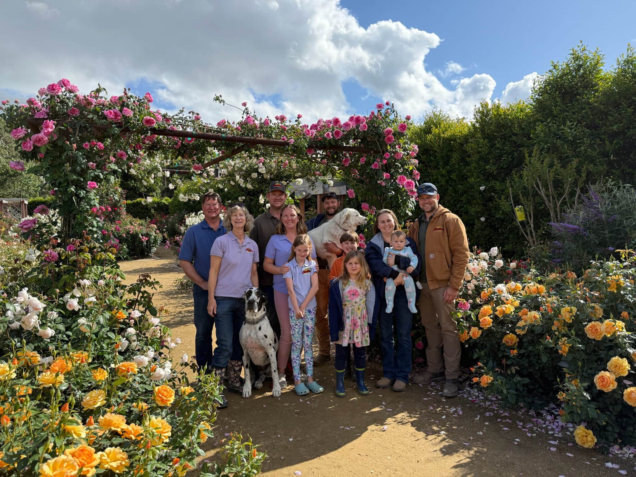 Family and friends at Otto & Sons Nursery with colorful roses and garden scenery.